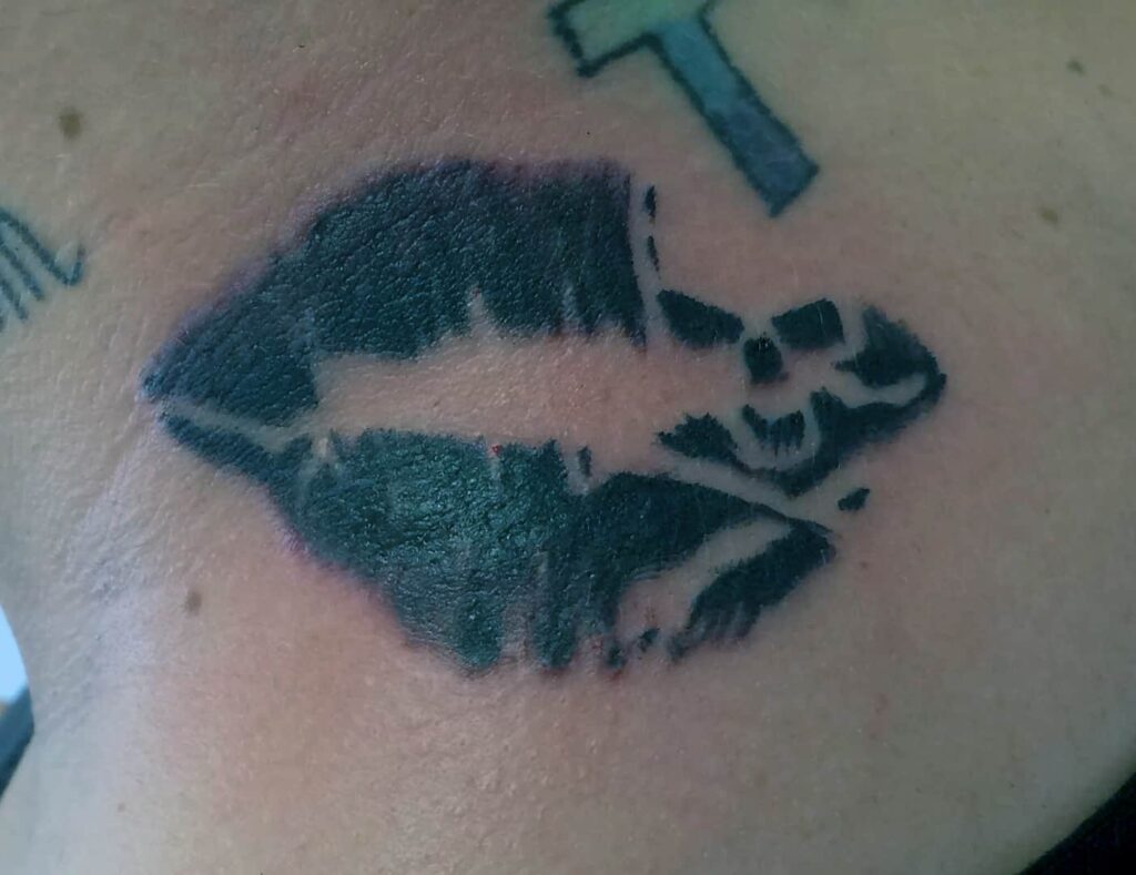 Black lipstick with skull imprint tattoo. John at Rogsy Tattoo Studio.